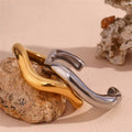 Gold and silver curled hook cuff bracelets on stone